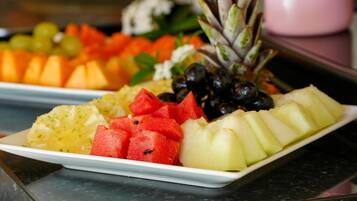 A fruit platter with watermelon, pineapple, grapes, and melon slices.