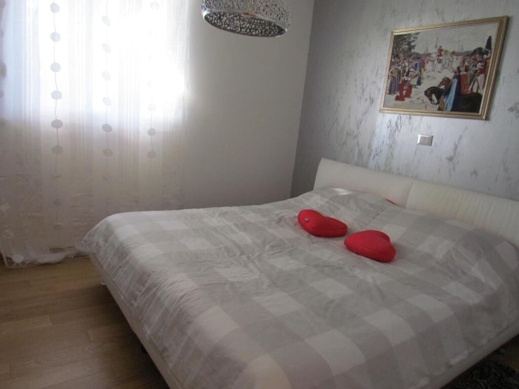Un dormitorio con una cama grande, un cuadro en la pared y una araña.