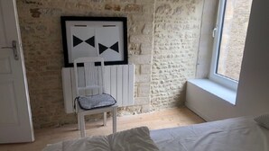 A bedroom with a bed, a chair, and a window. - Magnifique Maison de Ville Familiale (Courseulles-sur-Mer)