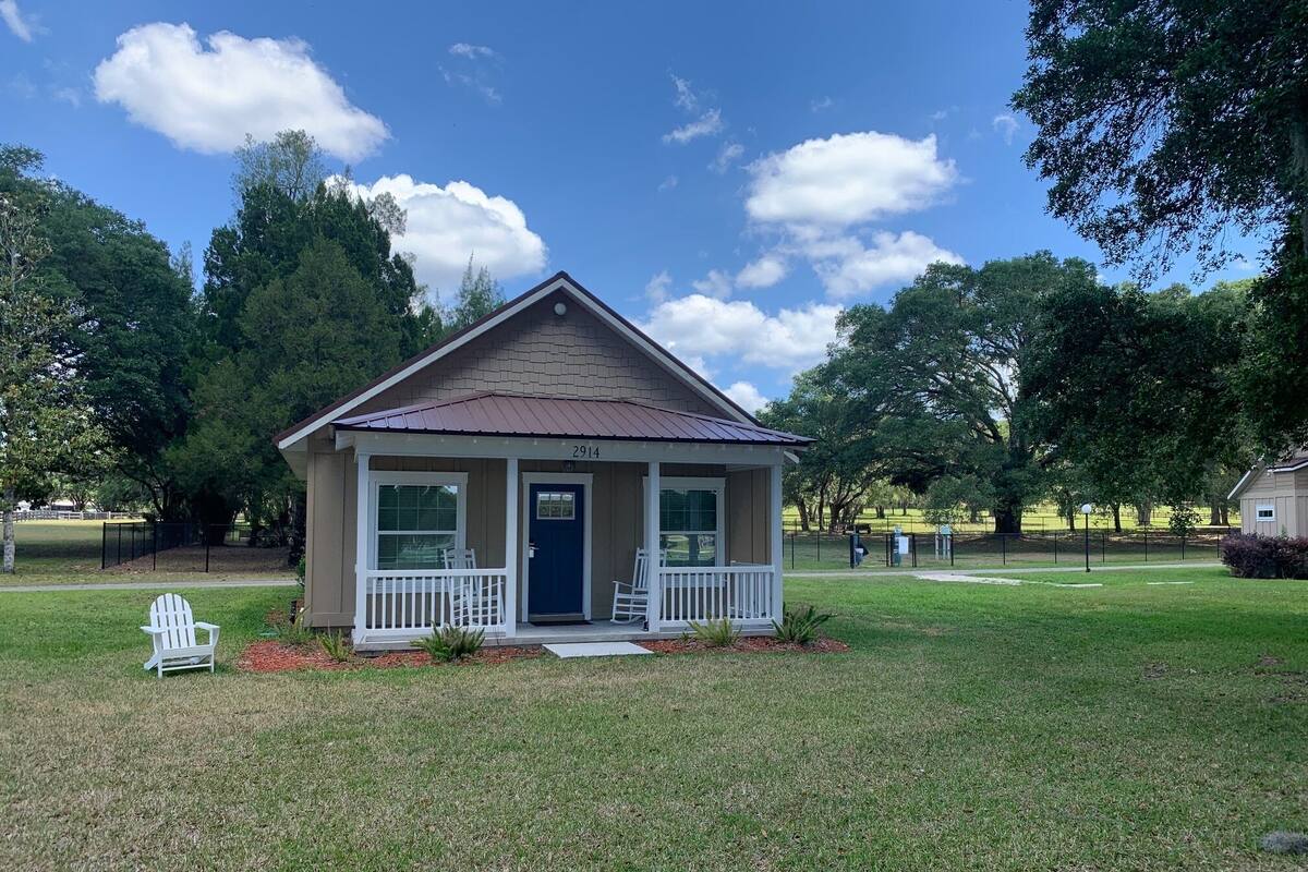 A small, single-story house with a front porch, a blue door, and the number 2914 on the front.