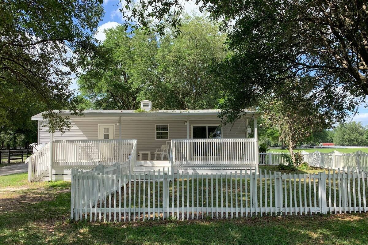 A single-story house with a porch and a white picket fence.