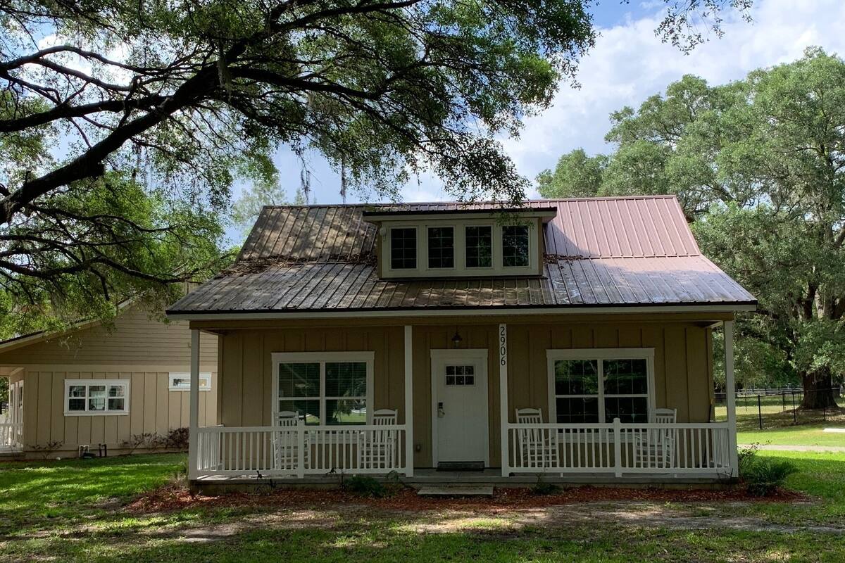 A two-story house with a front porch, a small attached garage, and a number '2906' on the front door.