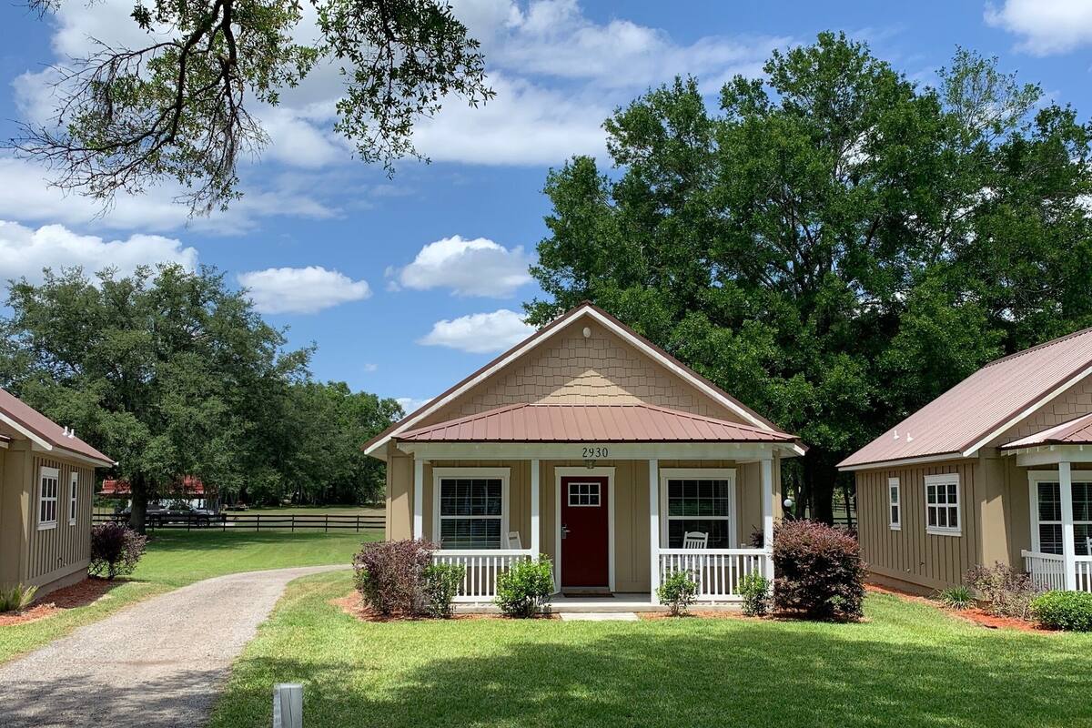 A two-story house with a front porch, a red door, and the number 2930 on the front.