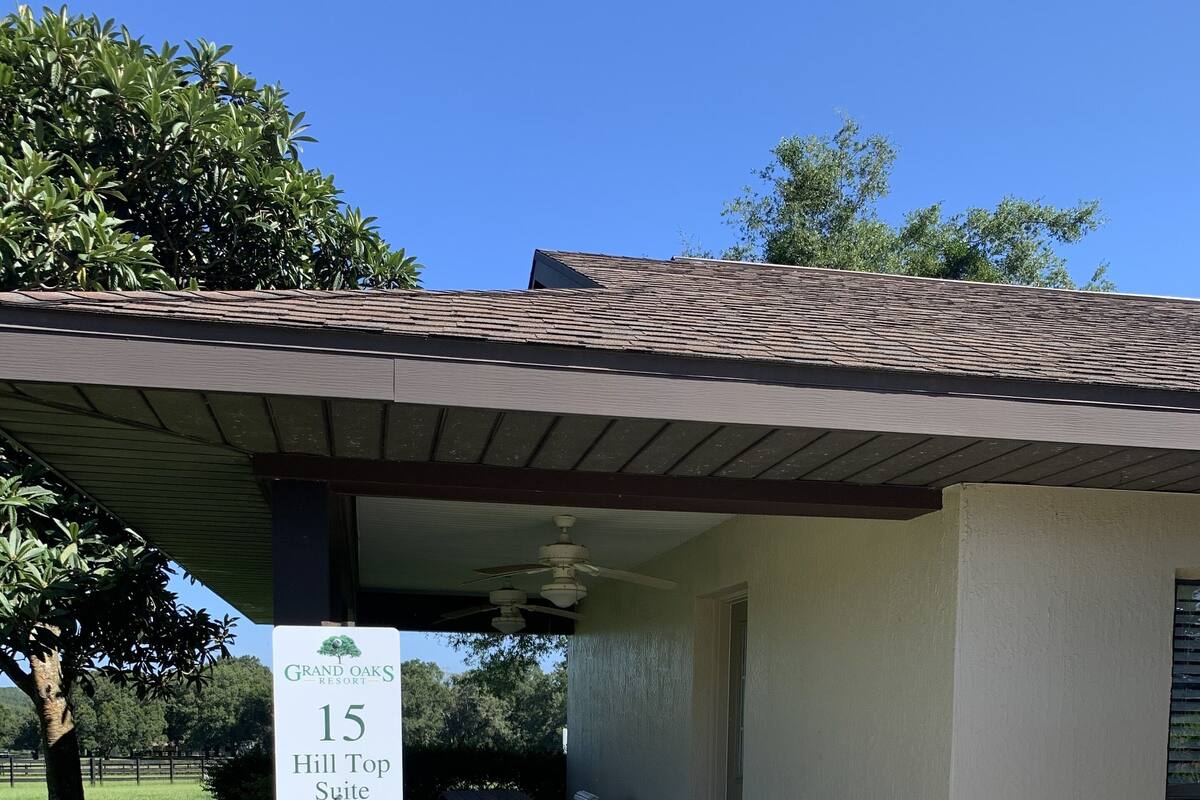 A covered outdoor seating area with a sign for "Grand Oaks Resort 15 Hill Top Suite."