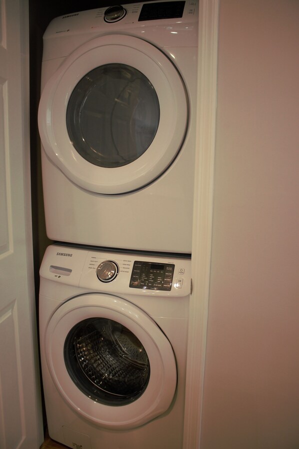 A stacked washer and dryer unit in a room.