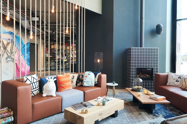 A modern living room with leather sofas, a wooden coffee table, and a fireplace.