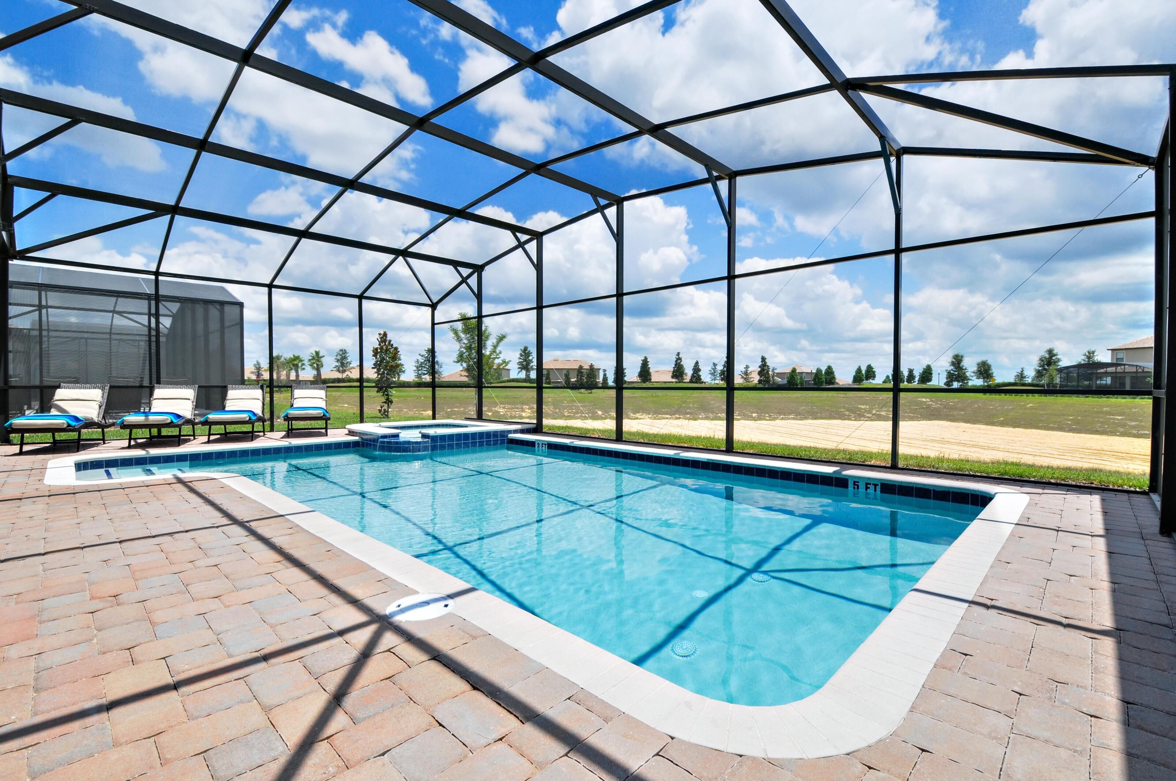 A covered outdoor swimming pool with a clear view of the sky and distant landscape.