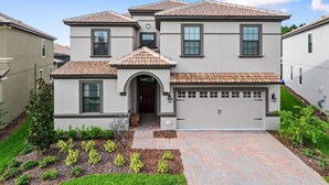 A two-story house with a garage, a front entrance with a door, and a tiled roof. - 1461rf - NON Renting 1/5/2022 The Retreat at Championsgate (Davenport)
