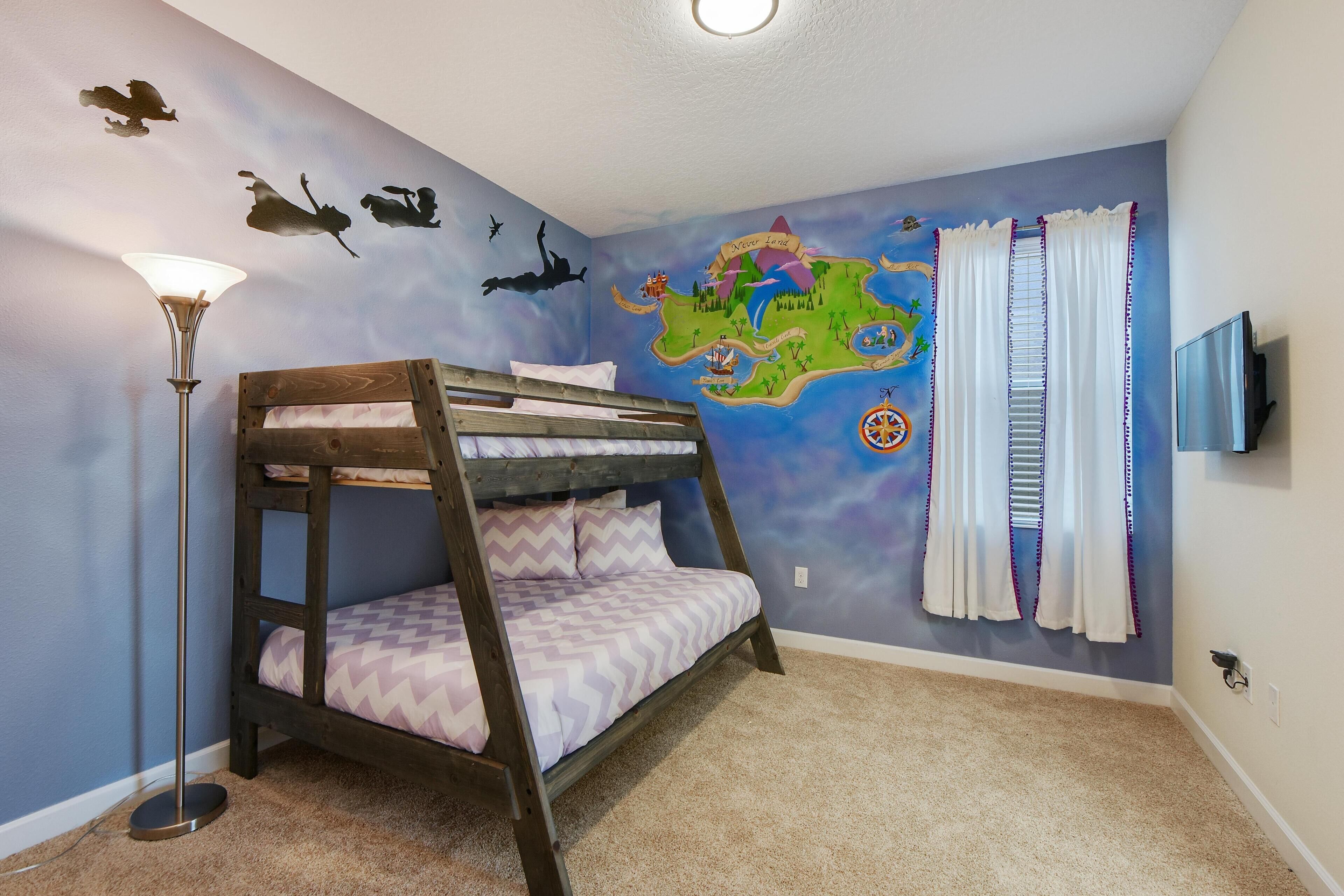 A room with a bunk bed, a wall map, a floor lamp, and a TV.