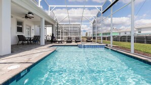 Una piscina con sillas de descanso y un patio techado.