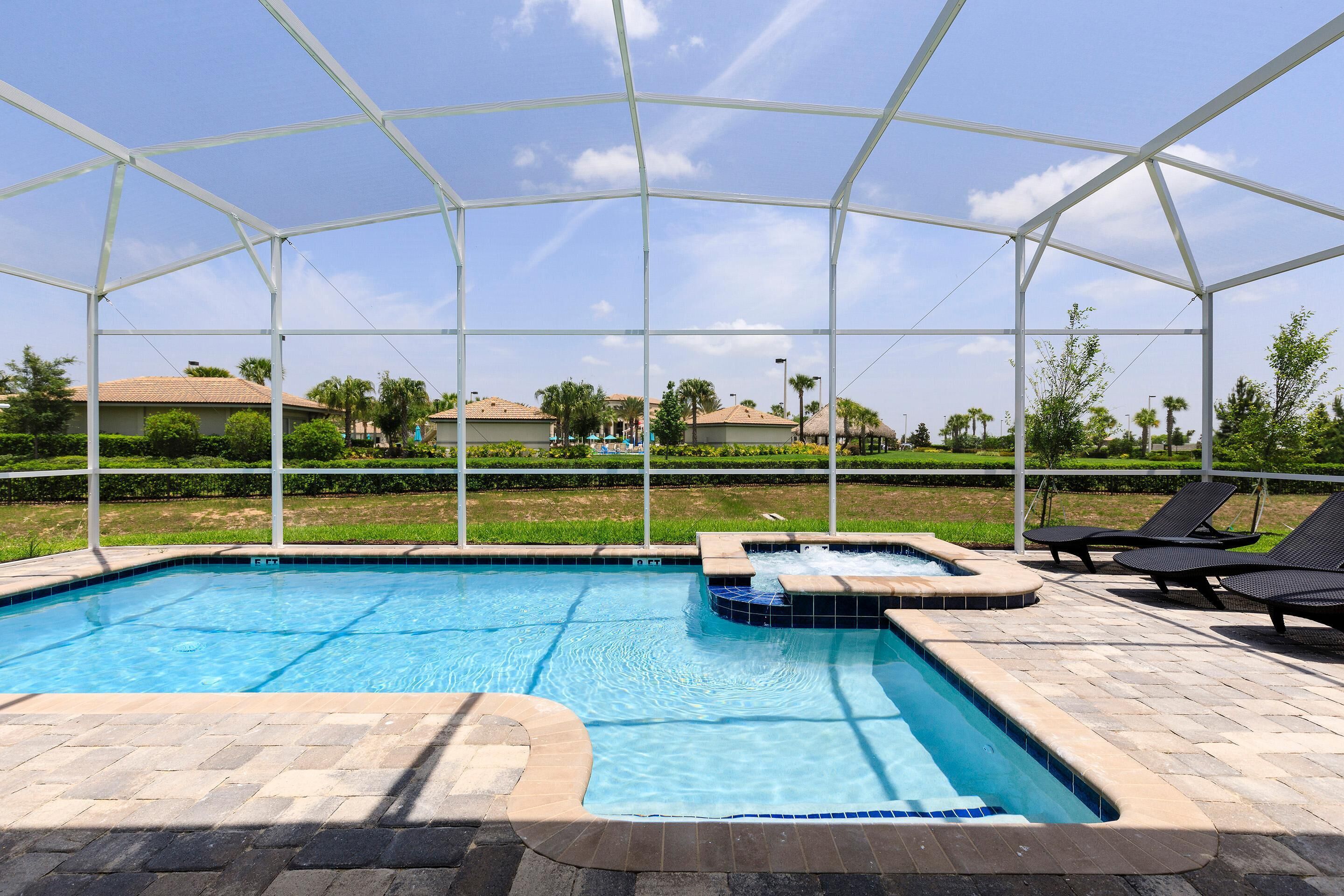 Une piscine extérieure couverte, dotée de chaises longues et d’un jacuzzi.