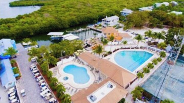 A resort with a large pool, a beach area, and a view of the sea. - Near beach, includes golf cart , bikes , kayaks and pool , 5 stars. NCIC member (Captiva)