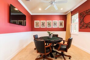 A conference room with a round table, four chairs, a ceiling fan, and framed artwork on the walls. - 4049otd-solterra Gated Resort (Davenport)