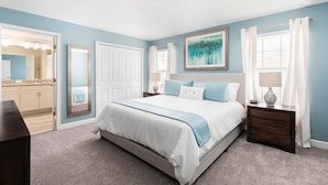A bedroom with a large bed, a nightstand, a dresser, and a mirror. - 9079dd-the Retreat at Championsgate (Davenport)