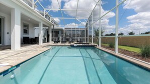 A swimming pool with a covered patio area, outdoor seating, and a view of the sky. - 1668mvd - Non-renting 6-12-2022 The Retreat at Championsgate (Davenport)