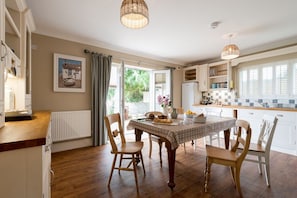 Kitchen dining table seating six with garden views, well-equipped self-catering kitchen at luxury holiday home sleeping eleven in Rhosneigr, Anglesey - Sand Dollar: family-friendly holiday home in Rhosneigr (Rhosneigr)