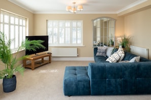 Relax in this inviting living room with a large TV, plush sofa, and matching ottoman.
