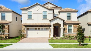 A two-story residential building with a tiled roof, a central entrance with a door, and a garage. - 1424ww - The Retreat at Championsgate (Davenport)