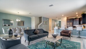 Un salon moderne avec un canapé, une table basse et un coin repas.