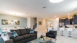 A modern living room with a sofa, coffee table, and a staircase leading to another level. - 1559pw NON Renting 8/15/21the Retreat at Championsgate (Davenport)