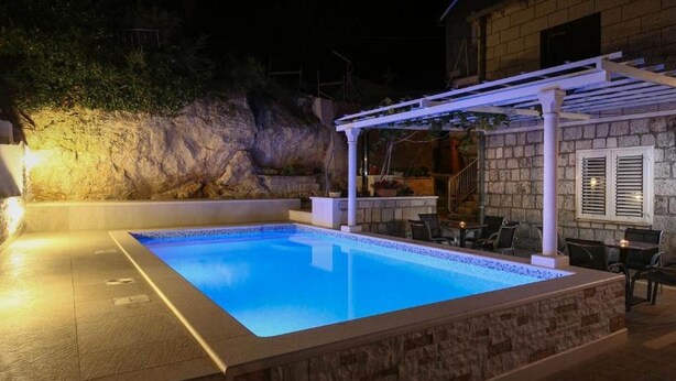 A swimming pool with a stone deck, a pergola, and outdoor seating. - Guest House Kusalo- Basic Triple Room with Patio (Dubrovnik)