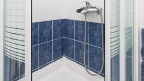 A corner shower with white and blue tiles, a glass enclosure, and a handheld showerhead. - Guest House Kusalo- Basic Triple Room with Patio (Dubrovnik)