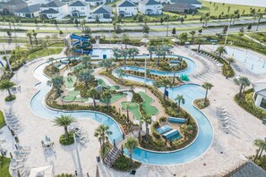 An aerial view of a resort with a winding pool, multiple green areas, and a large water slide. - 4563nl - Storey Lake Resort (Kissimmee)