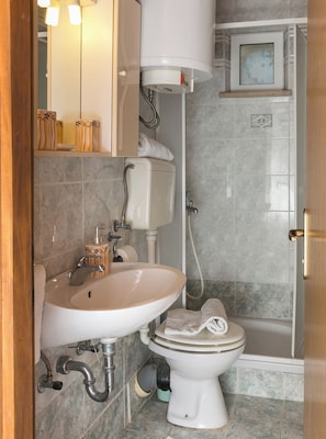 A bathroom with a toilet, sink, and shower.