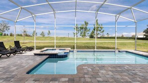 Et overdækket swimmingpool med liggestole og jacuzzi.