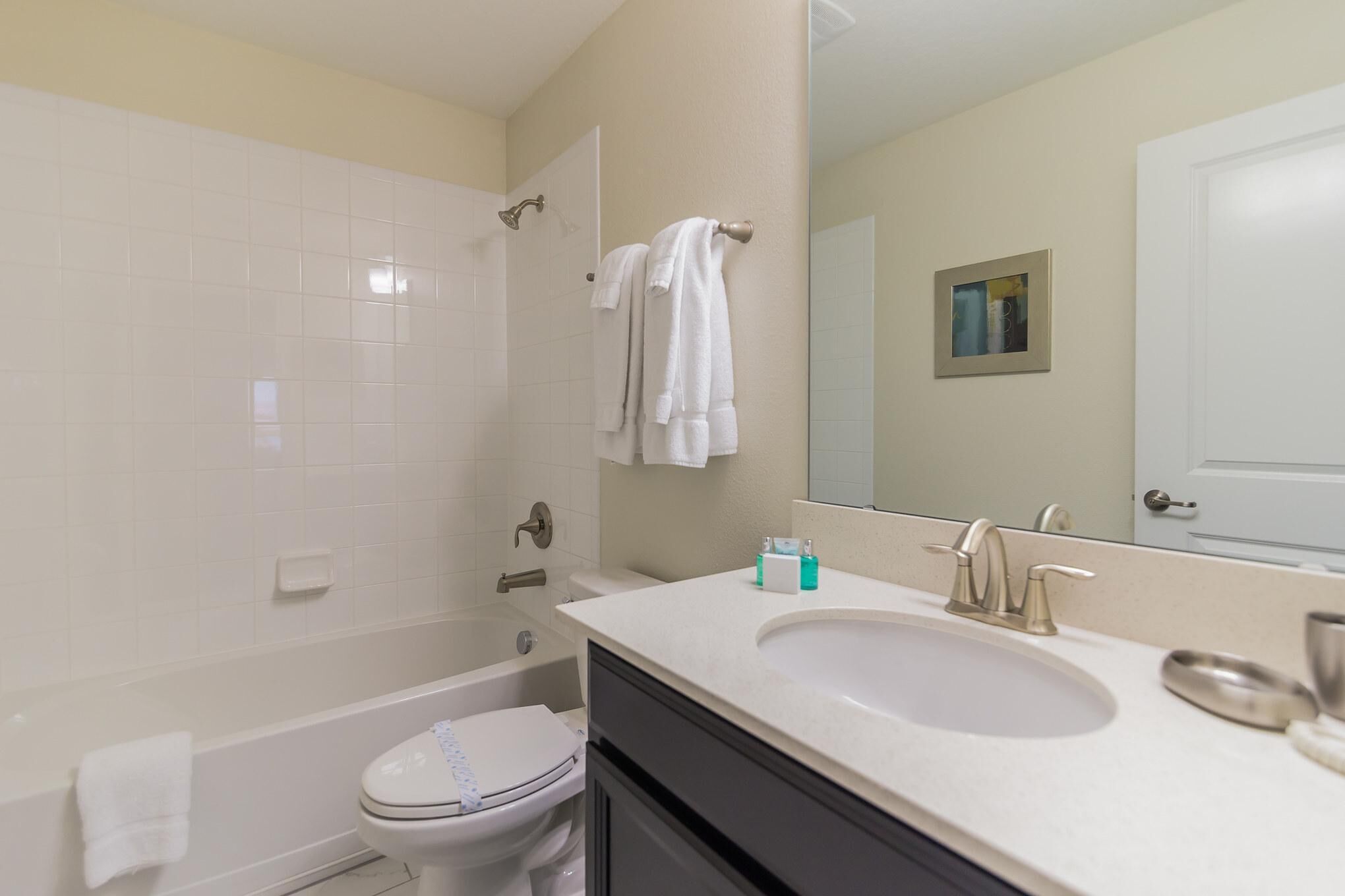 Ein Badezimmer mit Toilette, Badewanne, Waschbecken und Spiegel.