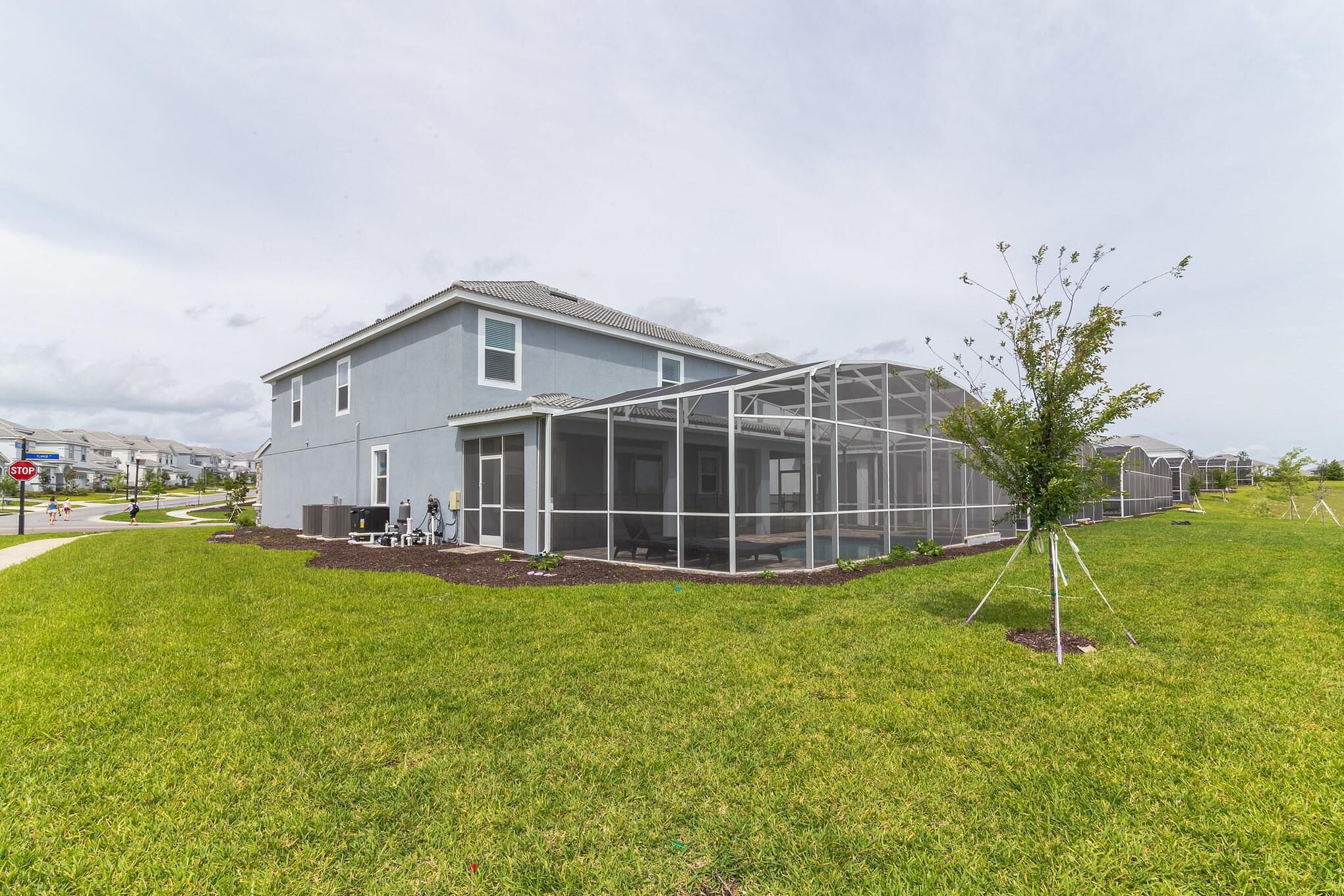 A house with a large glass greenhouse attached to the back.