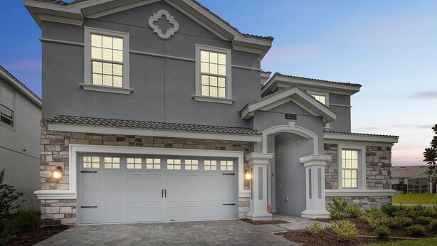 A two-story house with a garage, stone facade, and a well-maintained front yard. - Non-renting - 1533fd - The Retreat at Championsgate (Davenport)