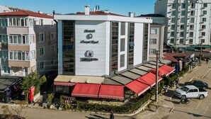 Um hotel com vários andares, janelas amplas e uma placa chamativa.