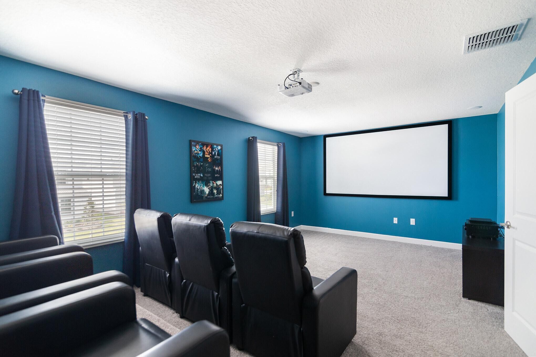 A home theater room with a large screen, ceiling fan, and blackout curtains.