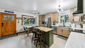Una cocina moderna con una isla central, armarios de madera y electrodomésticos de acero inoxidable, con vistas al lago Tahoe.