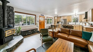 Una sala de estar acogedora con chimenea de piedra, un sofá de cuero y un comedor con mesa de madera.