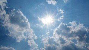 Le soleil brille à travers les nuages dans un ciel bleu clair.