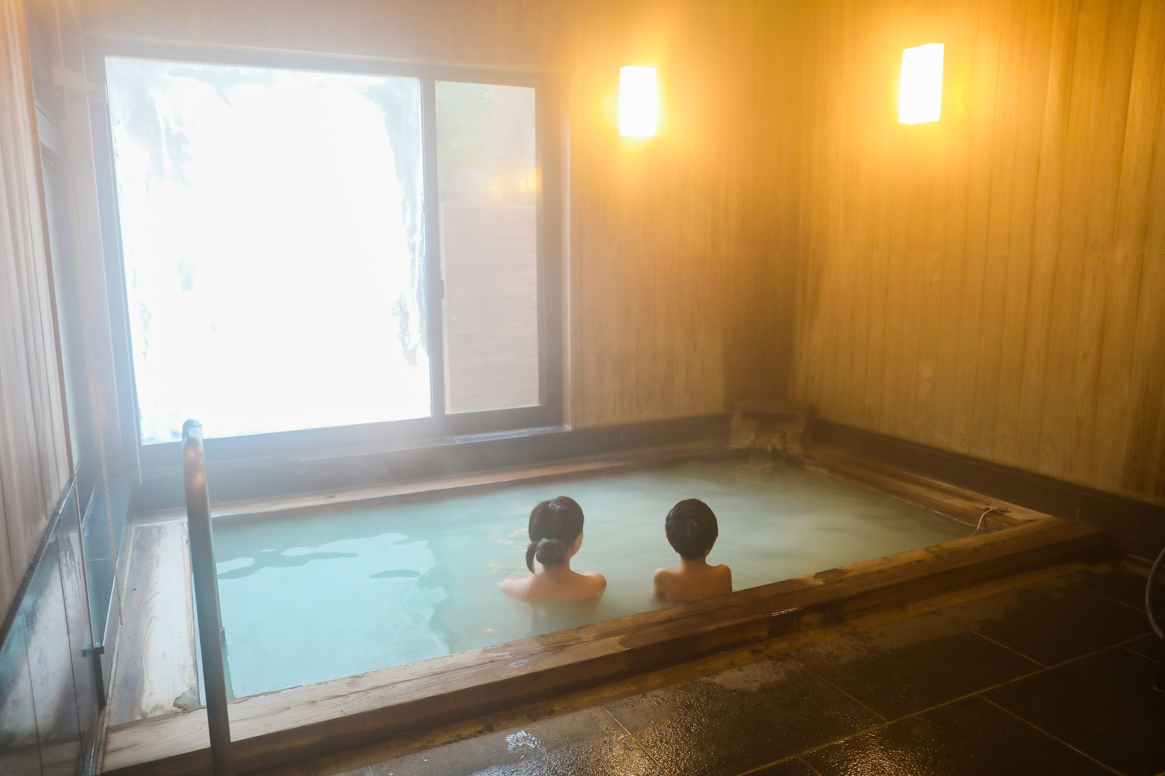 Ein Thermalbad mit Holzwänden und einem Fenster.