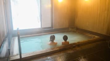 Ein Thermalbad mit Holzwänden und einem Fenster.