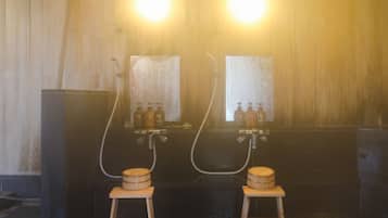 Una sala de sauna con dos bancos de madera, dos espejos grandes y dos botellas de aceite en la pared.