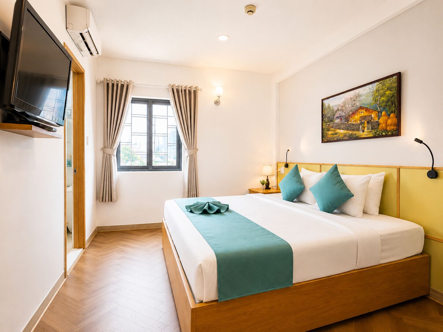 Una habitación de hotel con una cama, un televisor, una ventana con cortinas, un cuadro en la pared y una mesita de noche con una lámpara.