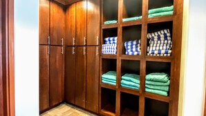 A walk-in closet with wooden cabinets and shelves, containing folded towels and blankets. - Managed by Park City Lodging-Hotel Room Ski-In/Out-Park City Mtn-Hot Tub/Pool (Park City)