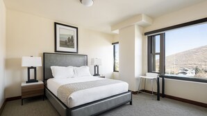 A modern hotel room with a large bed, two bedside tables with lamps, a small desk, and a large window offering a view of the hills. - Managed by Park City Lodging-Hotel Room Ski-In/Out-Park City Mtn-Hot Tub/Pool (Park City)