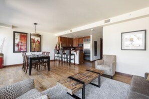 Uma sala de estar moderna com área de jantar, cozinha e vista para a cidade.