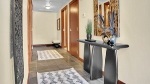 A hallway with a reception desk, a mirror, and a potted plant. - Luxury Ski-In/Out at Park City Mtn-Pool/Hot Tub I Managed by Park City Lodging (Park City)