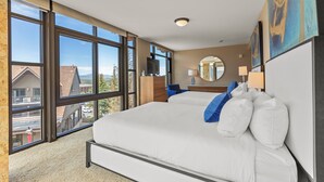 Ein Schlafzimmer mit einem großen Bett, einem Fernseher und Blick ins Freie.