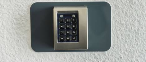 A keypad lock on a textured wall.