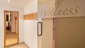 Un pasillo con un espejo, un perchero y un letrero que dice 'Wellness'.
