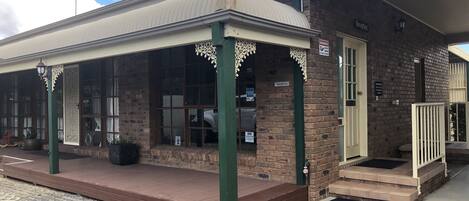 A brick building with a reception area, large windows, and a covered entrance with decorative elements.