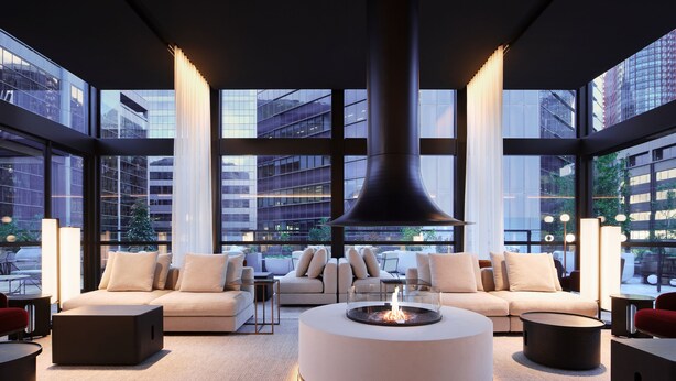 A modern living room with a central round coffee table, sofas, and a large window offering a city view. - Little National Hotel Sydney (Sydney)